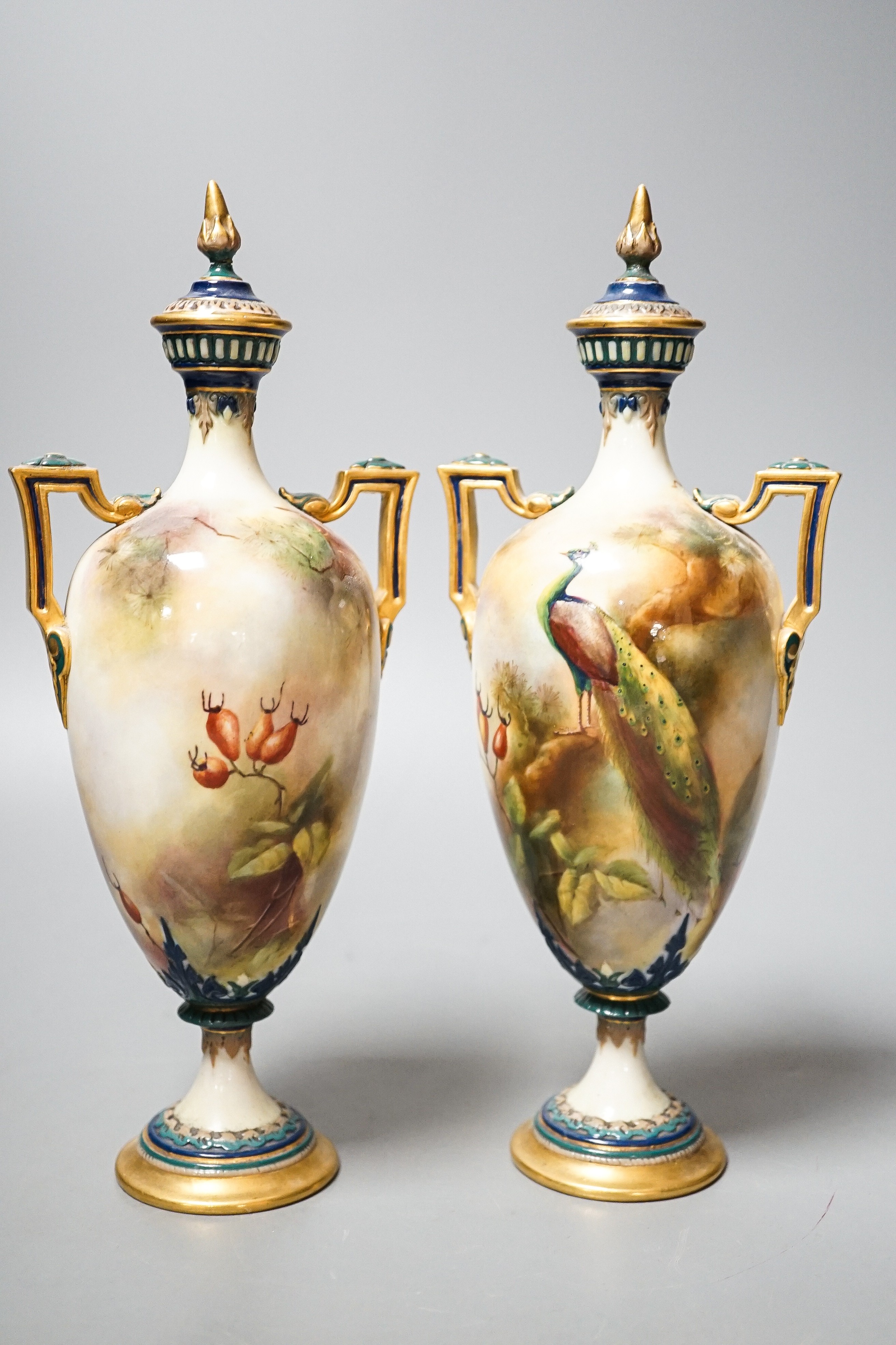 A pair of Royal Worcester Hadley ware Peacock vases and covers 24cm